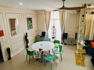 Elegant living room with modern decor and stylish furniture, featuring a round table and vibrant green chairs.