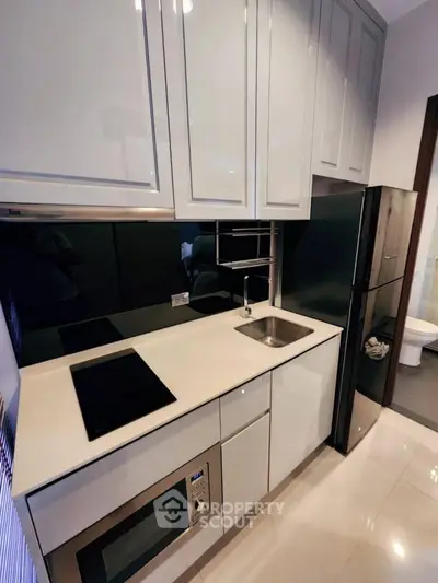 Modern compact kitchen with sleek cabinets and built-in appliances