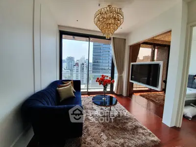 Luxurious living room with elegant chandelier and city view, featuring plush sofa and modern decor.