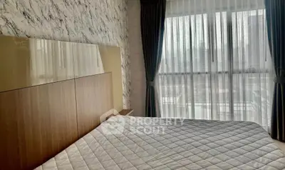 Modern bedroom with large window and stylish decor in a luxury apartment.