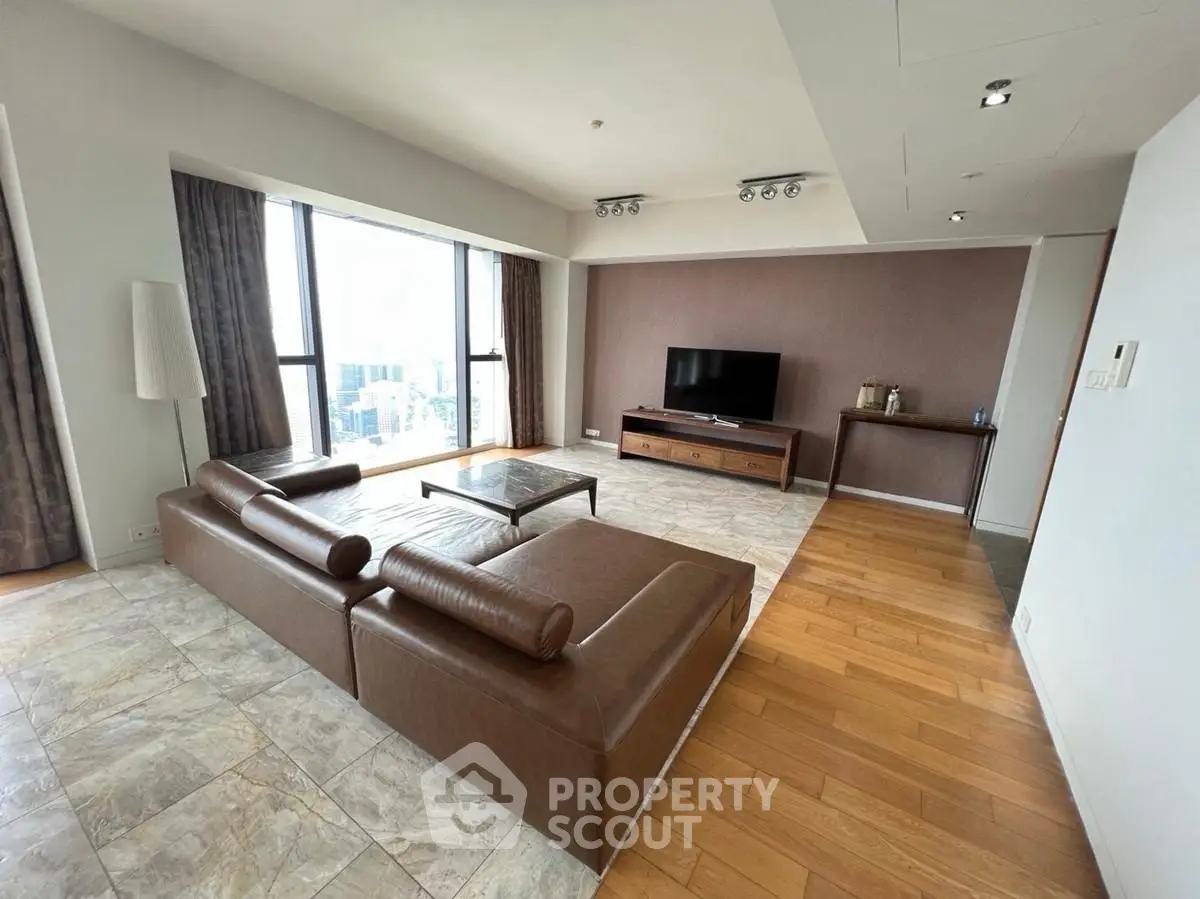 Spacious modern living room with leather sofa and city view, perfect for urban living.