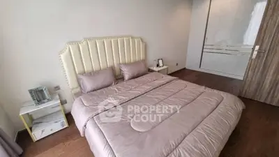 Luxurious bedroom with elegant decor and plush bedding in modern apartment.