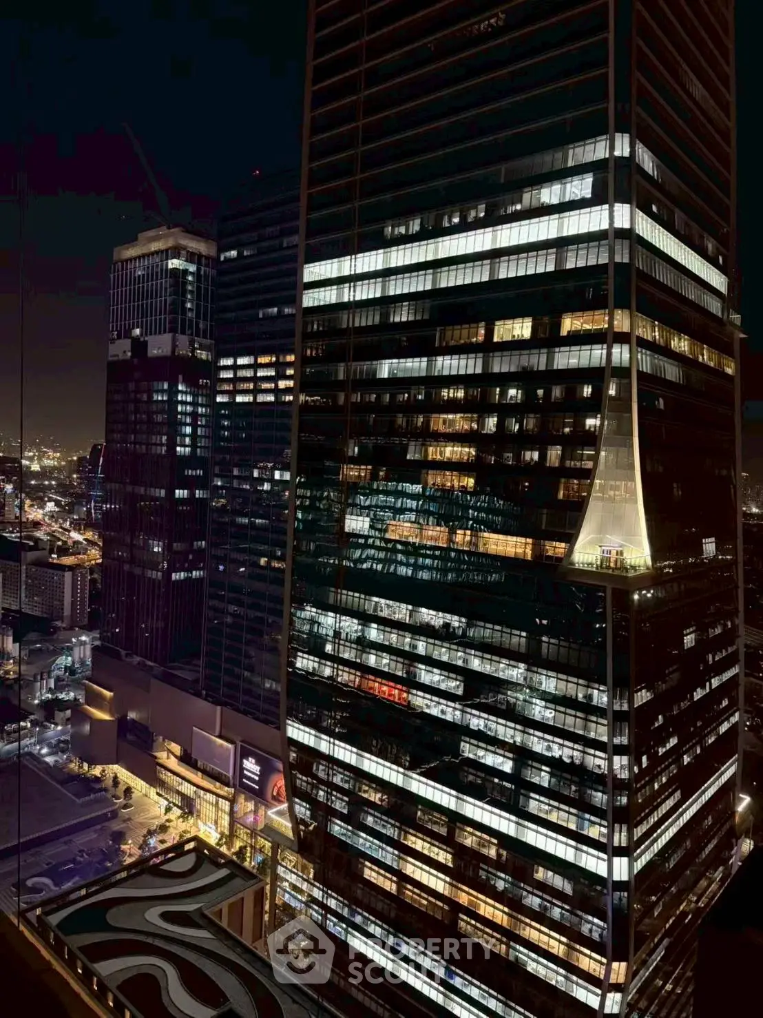 Stunning night view of illuminated skyscraper in bustling cityscape.