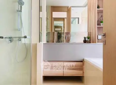 Modern bathroom with sleek shower and wooden cabinetry in a stylish apartment.