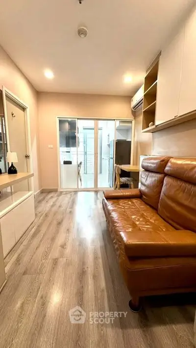 Modern living room with leather sofa and wooden flooring in a cozy apartment