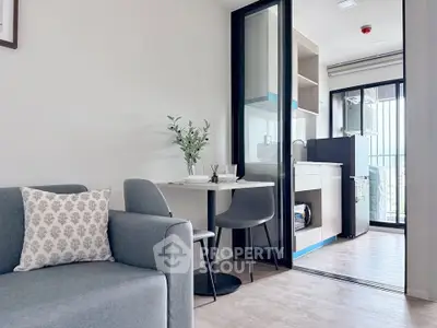 Modern open-plan living room with kitchen and balcony in a stylish apartment.
