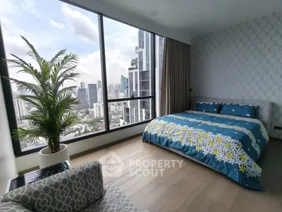 Modern bedroom with large windows offering stunning city views and stylish decor.