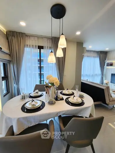 Elegant dining area with modern decor and large windows in a stylish apartment.