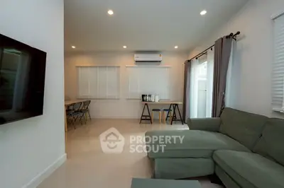 Spacious living room with modern decor and natural light, featuring a comfortable sofa and dining area.