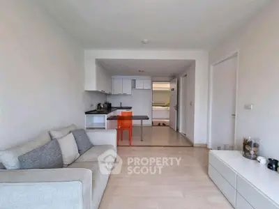 Modern open-plan living room with sleek kitchen and cozy sofa