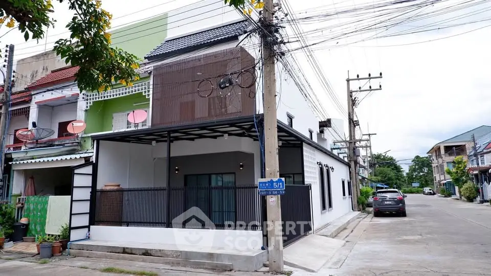 Modern townhouse with sleek facade and spacious driveway in urban neighborhood.
