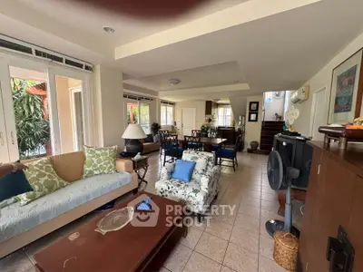 Spacious living room with elegant decor and abundant natural light, featuring cozy seating and stylish furnishings.