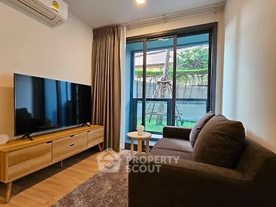 Cozy living room with modern decor and large TV, perfect for relaxation.
