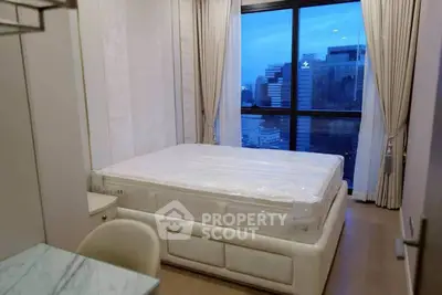 Luxurious bedroom with city view, featuring elegant decor and large window for natural light.