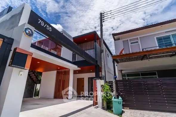 Modern two-story house with sleek design and spacious driveway under a clear blue sky.