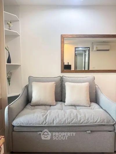 Cozy living room with stylish gray sofa and elegant wall mirror