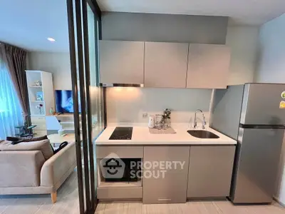 Modern open-layout kitchen with sleek cabinetry and integrated appliances in a stylish apartment.