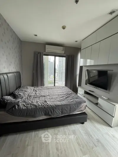 Modern bedroom with city view, sleek furniture, and stylish decor in high-rise apartment.