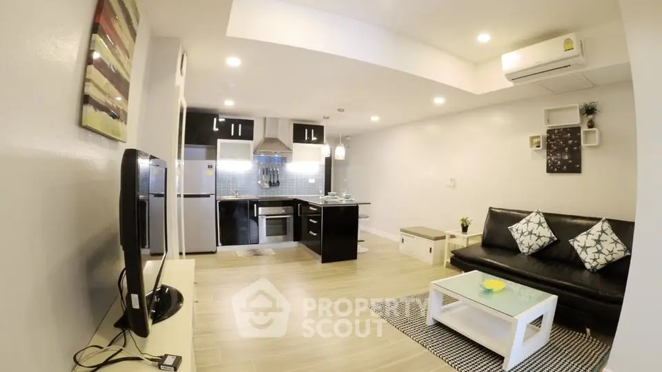 Modern open-layout living room with sleek kitchen and stylish decor