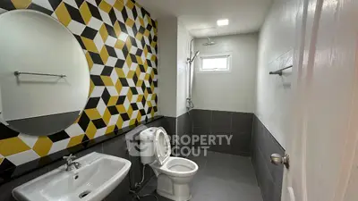 Modern bathroom with geometric tile design and sleek fixtures
