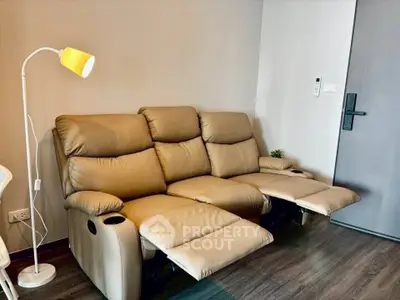 Modern living room with comfortable recliner sofa and stylish floor lamp.