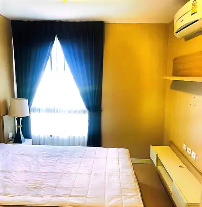 Cozy bedroom with natural light and modern furnishings in a stylish apartment.