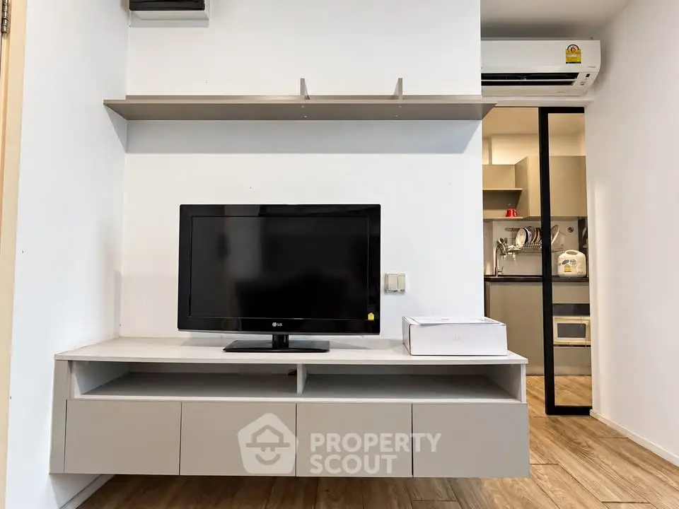 Modern living room with sleek TV unit and open kitchen layout