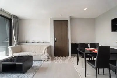 Modern living room with sleek furniture and dining area in a stylish apartment.