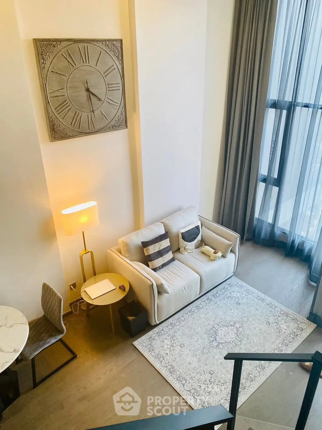 Stylish living room with high ceilings, large windows, and modern decor in a contemporary apartment.