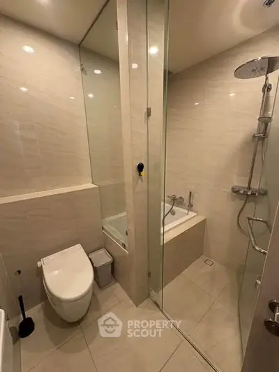 Modern bathroom with glass shower and bathtub in luxury apartment