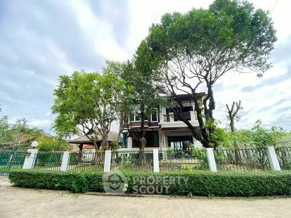 Charming two-story house with lush garden and mature trees, perfect for serene living.