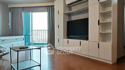 Modern living room with balcony, sleek cabinetry, and wooden flooring.