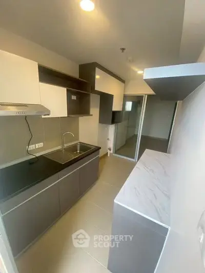 Modern kitchen with sleek cabinetry and ample counter space in a contemporary apartment.