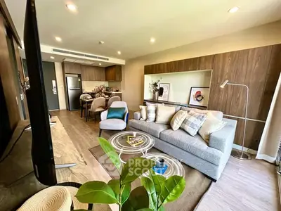 Modern open-layout living room with stylish decor and kitchen area, perfect for urban living.