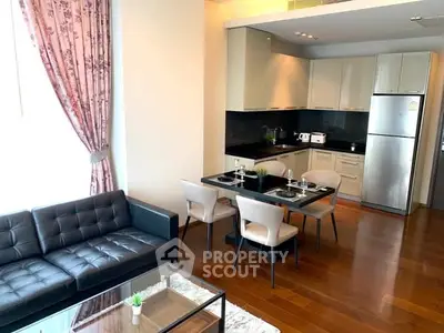 Modern open-layout kitchen and living room with stylish furniture and natural light.