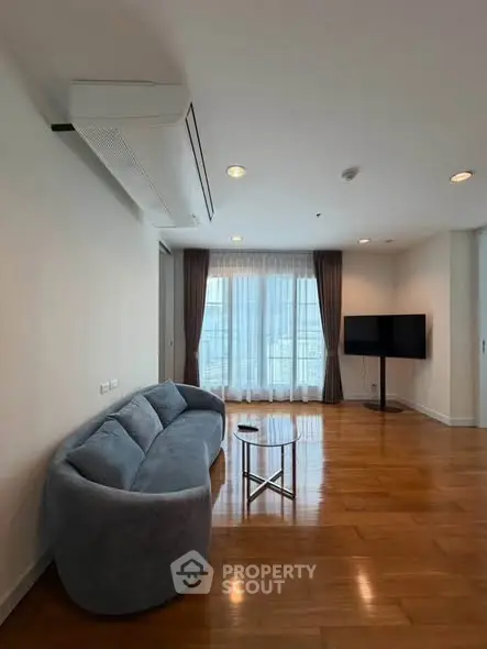 Spacious living room with modern sofa and large window offering natural light.