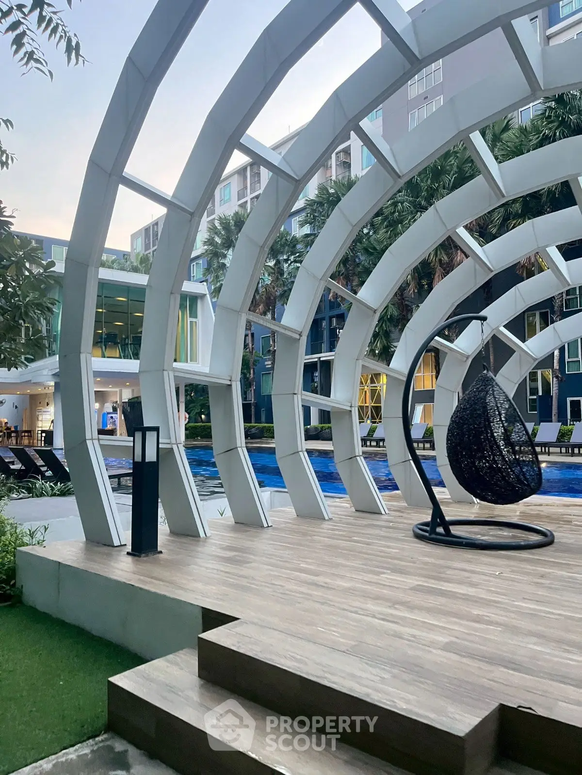 Modern apartment complex with stylish poolside seating and unique architectural design.
