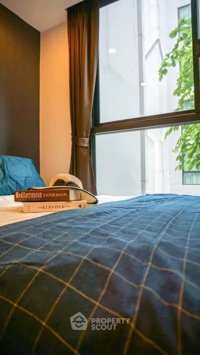 Cozy bedroom with large window and stylish decor in modern apartment