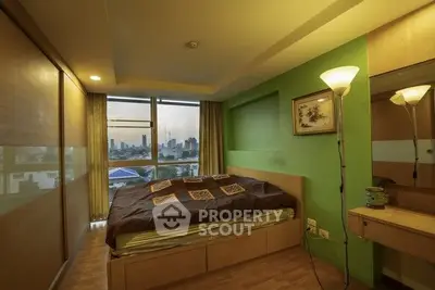 Cozy bedroom with city view, warm lighting, and modern decor.
