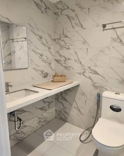 Modern bathroom with marble tiles and sleek fixtures in a contemporary apartment.