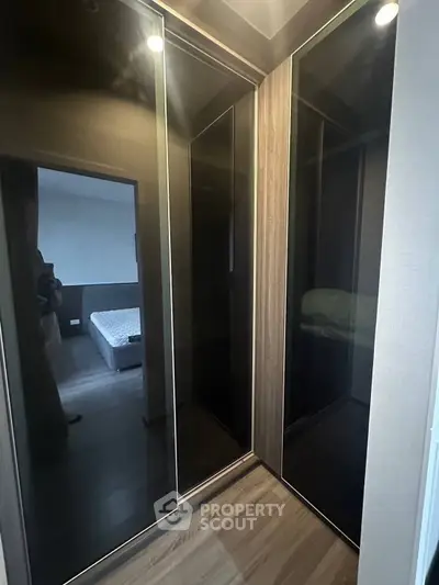 Modern bedroom with sleek mirrored wardrobes and cozy bed setup