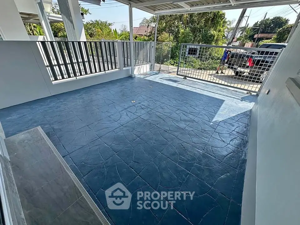 Spacious outdoor patio with modern railing and textured flooring, perfect for relaxation and entertainment.