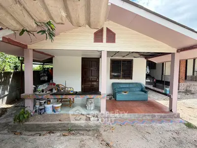 Charming single-story home with covered porch and outdoor seating area, perfect for relaxation.