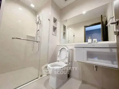 Modern bathroom with glass shower and sleek fixtures in a contemporary home.