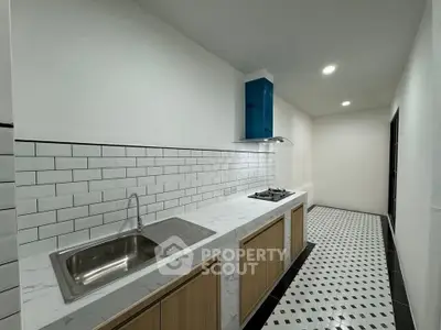 Modern kitchen with sleek design, featuring gas stove and stylish backsplash tiles.