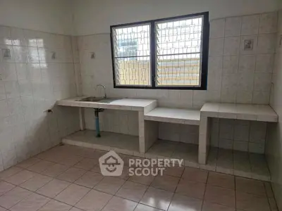 Spacious tiled kitchen with large windows and ample counter space