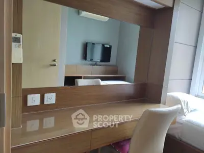 Modern bedroom with sleek wooden furniture and wall-mounted TV, perfect for urban living.