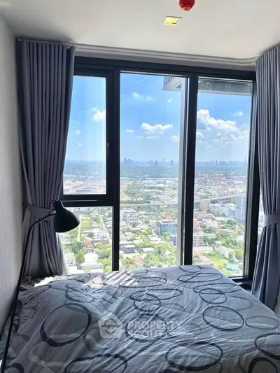 Stunning bedroom with floor-to-ceiling windows offering panoramic city views.