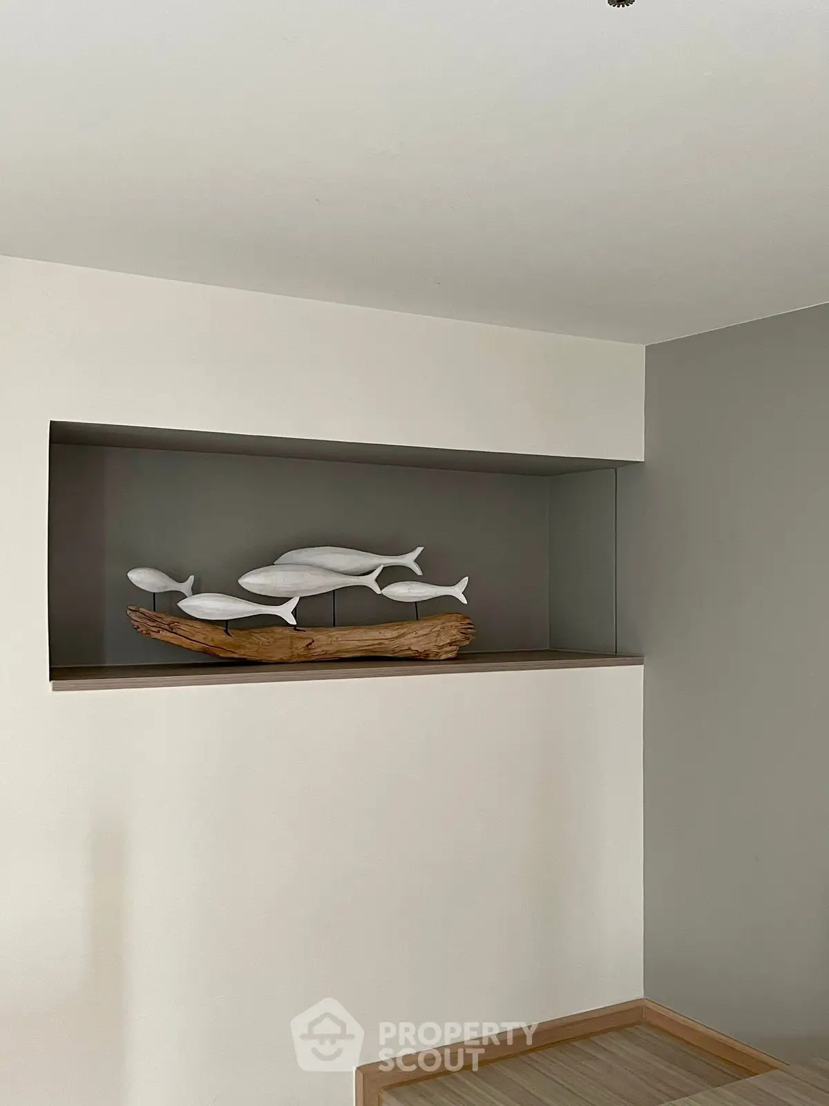Modern interior with minimalist fish sculpture on wooden shelf