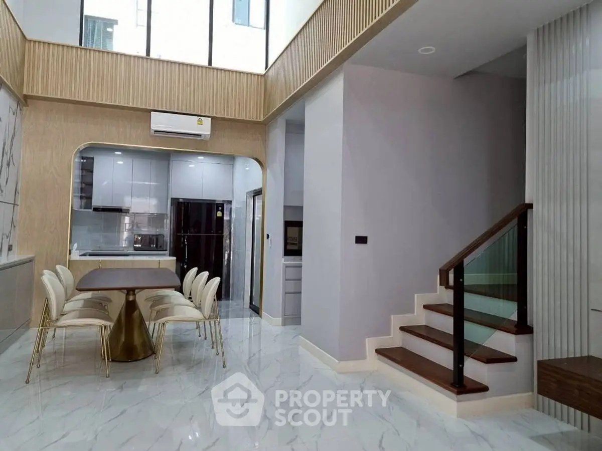 Luxurious open-plan dining area with modern staircase and high ceilings